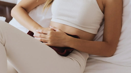 Femme allongée avec des douleurs au ventre qui va pratiquer une thérapie holistique