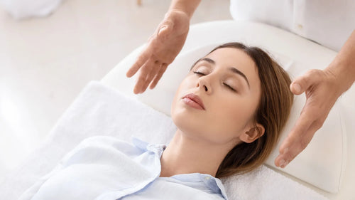 Un maître Reiki utilise ses mains autour de la tête d'une patiente pour harmoniser les énergies