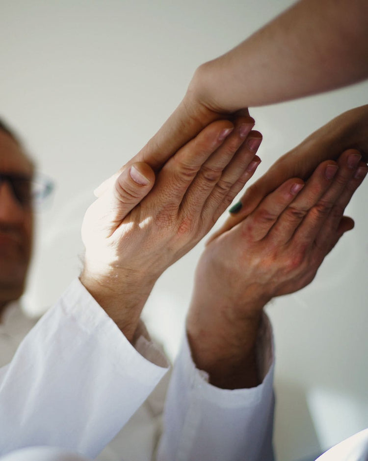 Poser ses mains en dessous de celles de la patiente pour ressentir les énergies du Reiki